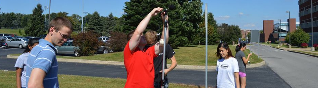 Students taking outdoor noise measurements on a sunny day. 